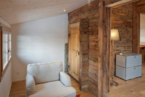Umbau historisches Walliser Haus in Bellwald Sitzecke mit alter Holztüre